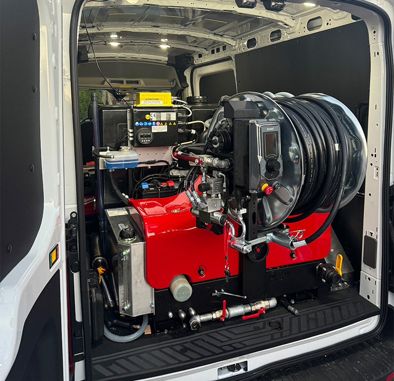 Interior of service van showing installed drain‑cleaning equipment and hose reel