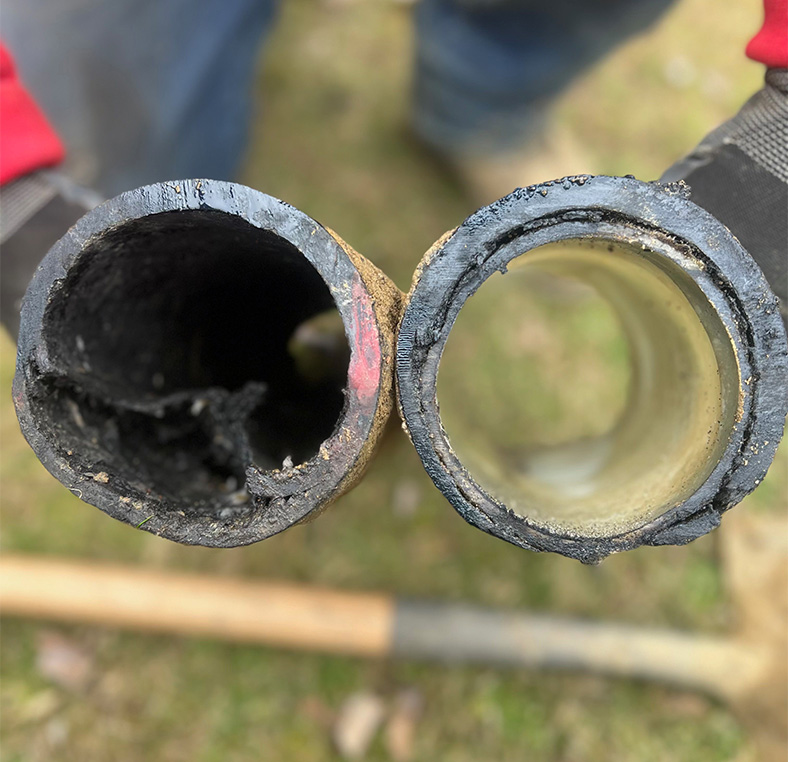 Side‑by‑side comparison of a corroded pipe segment and a clean replacement section